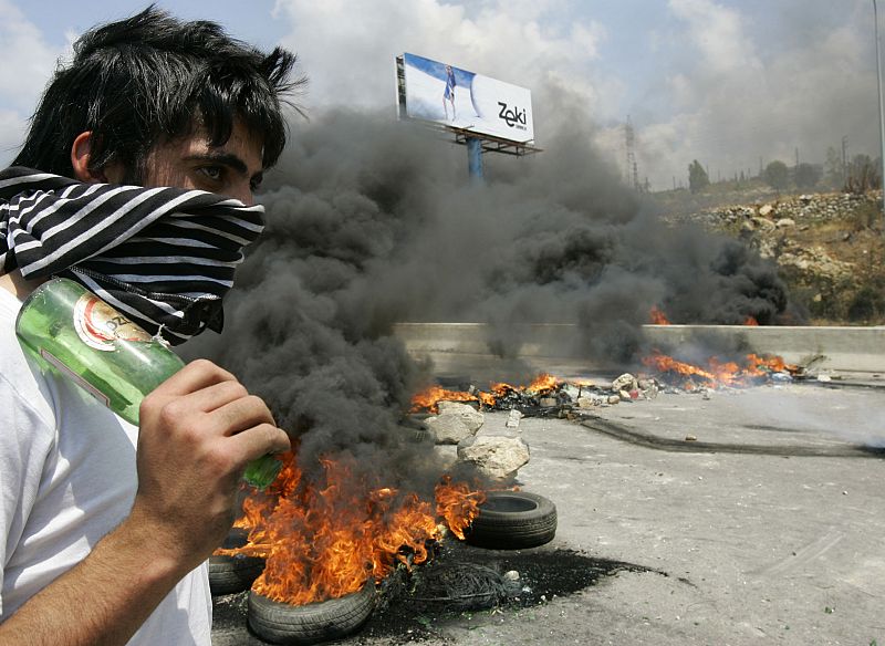 Un libanés, entre el fuego y las barricadas en una de las autopistas del sur de Líbano.ay leading to southern Lebanon in Jiyeh area south of Beirut