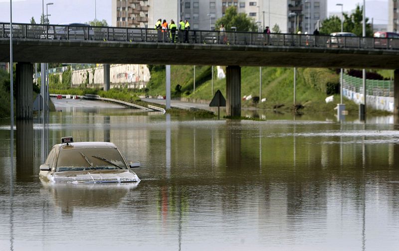 Aspecto que presentaba esta mañana la carretera N-637 a su paso por la localidad vizcaína de Berango, que permanece cortada debido a las intensas lluvias caídas ayer en la zona.