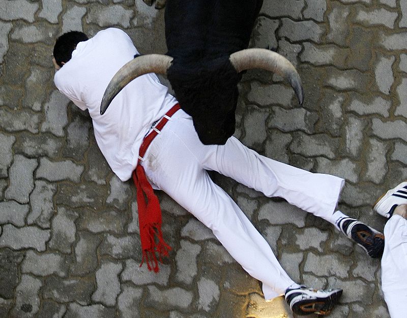A fallen runner gets trampled by a bull during the fourth bull run of the San Fermin festival in Pamplona