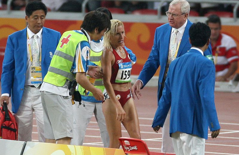 Dominguez recibe ayuda tras caerse a media vuelta de la final de los 3.000 metros obstáculos femeninos.