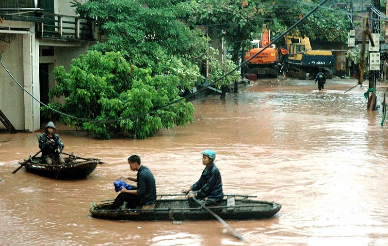 Residents row boats along flooded road in Vietnam's northern Quang Ninh province