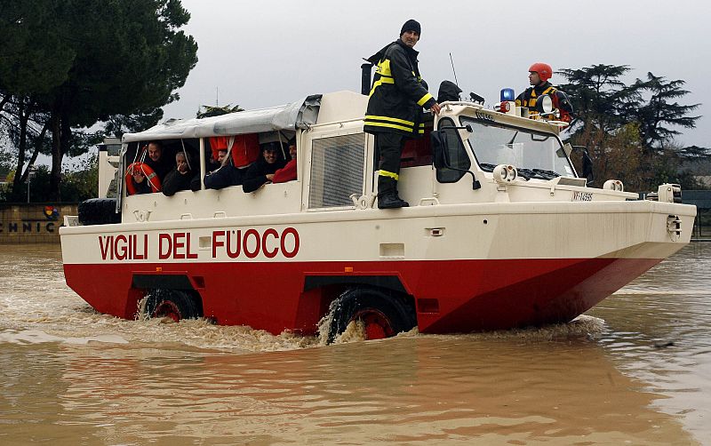 Fire department rescuers use an amphibious vehicle to ferry stranded people through flood waters near Via Tiburtina in Rome