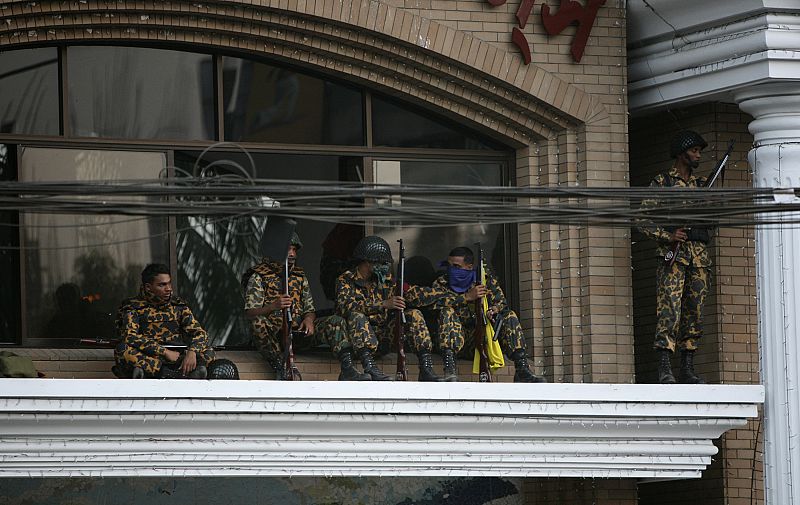 Soldados rebeldes de guardia en la puerta de los paramilitares de los Rifles de Bangladesh ,