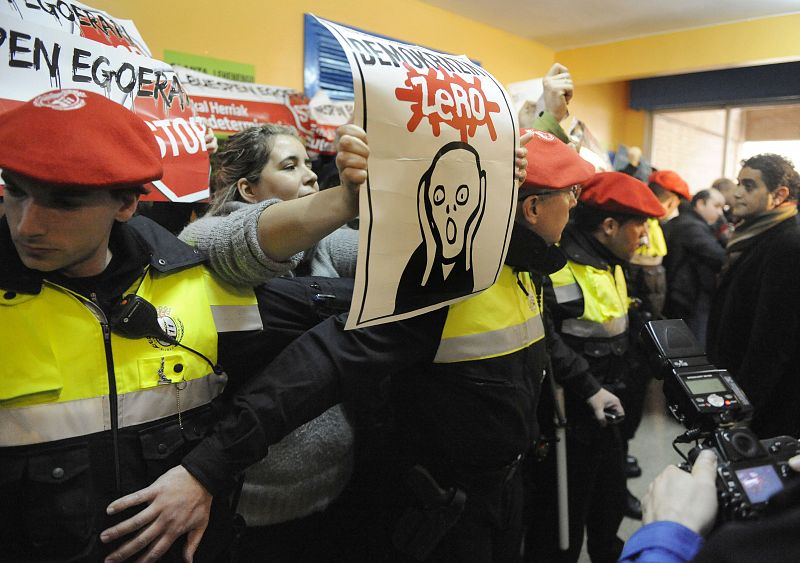 Police hold back banned pro-independence party D3M protesters as PSE leader Patxi Lopez votes in Bilbao