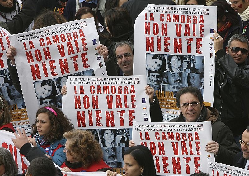 Demonstrators hold banners reading "Camorra worth nothing" as they march in the southern city of Naples