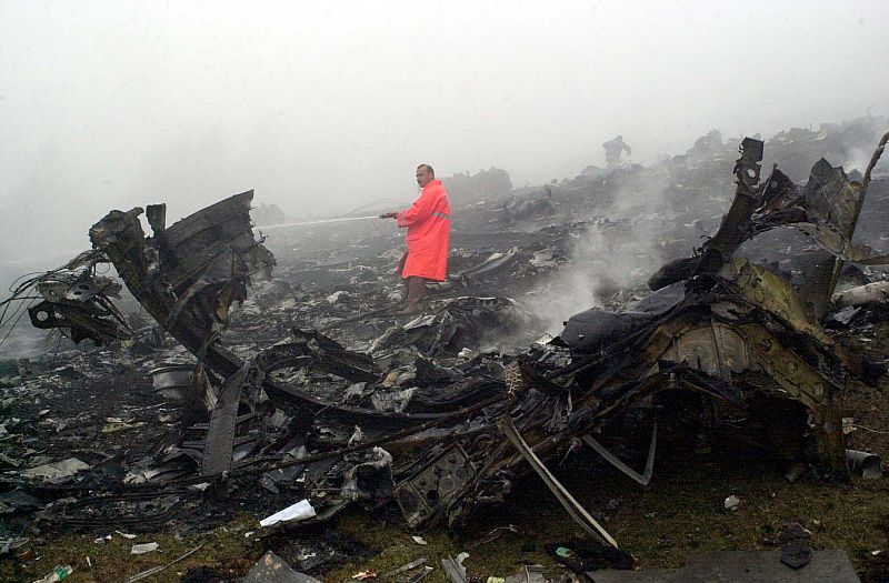 Un bombero turco intenta extinguir las llamas del Yak-42, que quedó completamente destrozado.