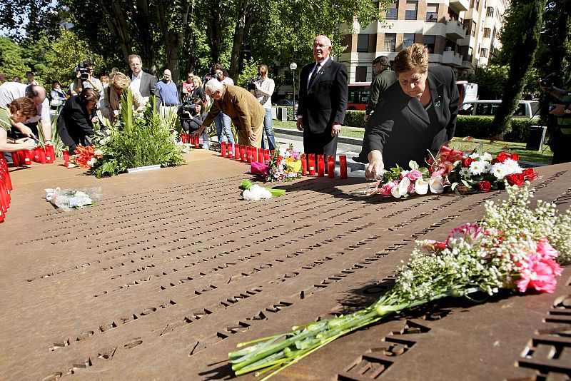 La madre de uno de los militares fallecidos en el Yak-42 deja un ramo de flores encima del monumento de los nombres de las víctimas