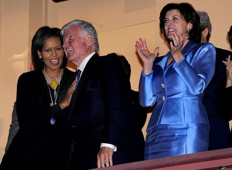 First lady Michelle Obama hugs Senator Ted Kennedy while Kennedy's wife Victoria (R) applauds at a musical tribute at the Kennedy Center in Washington