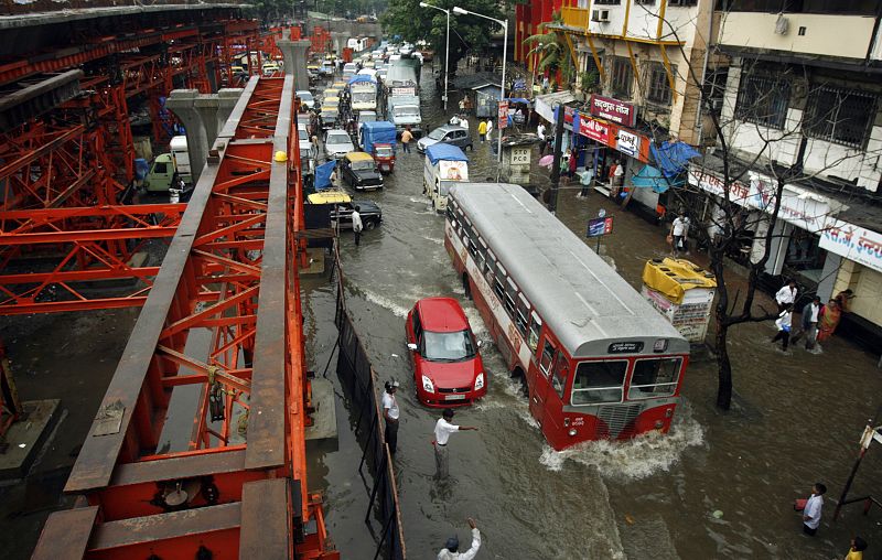 Traffic moves adjacent to a bridge under construction after heavy rains in Mumbai