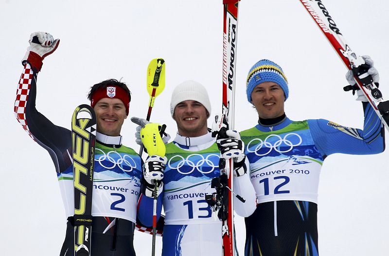 Croatia's silver medallist Kostelic, Italy's gold medallist Razzoli, and Sweden's bronze medallist Myhrer wave during a victory ceremony for the men's Alpine Skiing Slalom event at the Vancouver 2010 Winter Olympics in Whistler