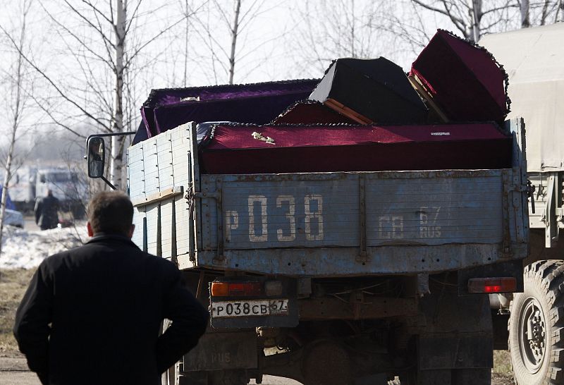 A man stands near a truck transporting empty coffins intended for the victims of a Polish government Tupolev Tu-154 aircraft crash in Smolensk