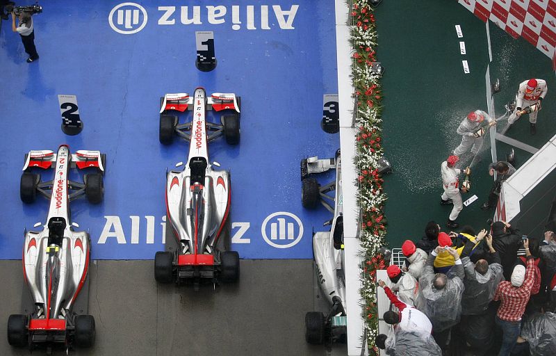 Jenson Button, con su compañero Lewis Hamilton en el podio y Nico Rosberg, ahora segundo en la clasificación mundial con 50 puntos.