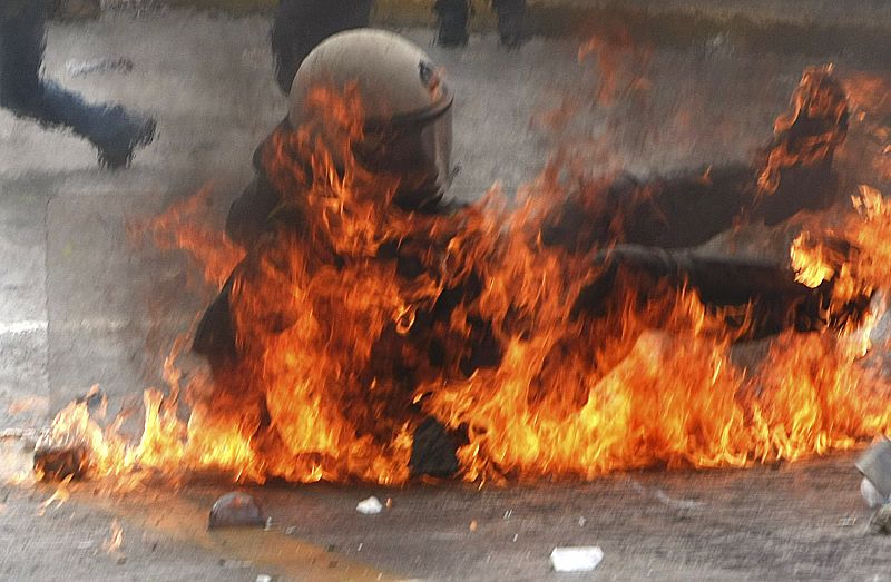 Un policía antidisturbios cae tras ser golpeado por un cóctel molotov lanzado por los manifestantes griegos.