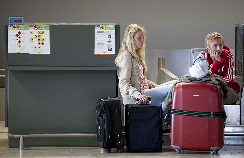 Dos pasajeros esperan en el aeropuerto de Sevilla, que junto con el de Jerez de la Frontera (Cádiz), están cerrados desde las 06.00 horas a causa de la evolución de la nube de cenizas procedentes del volcán islandés Eyjafjalla.