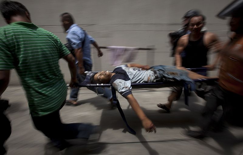 Anti-government 'red shirt' supporters carry the body of a man who was shot dead near Bangkok's Din Daeng intersection