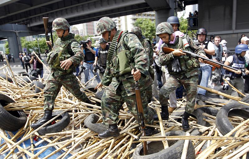 Los soldados superan las barricadas de bambú creadas por los "camisas rojas"
