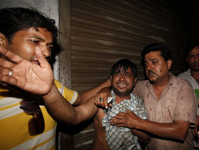 Locals mourn at the site of a fire in the old part of Dhaka