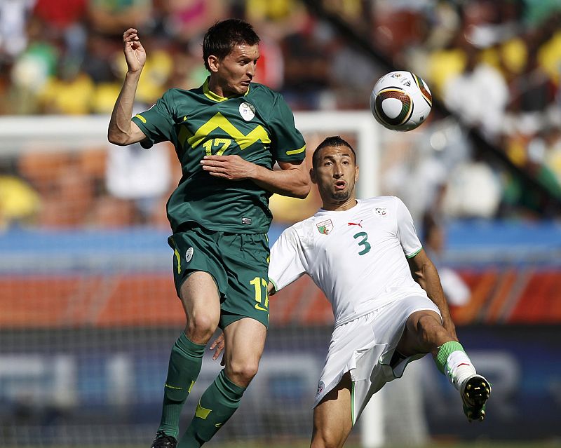 Slovenia's Kirm fights for the ball against Algeria's Belhadj during the 2010 World Cup Group C soccer match at Peter Mokaba stadium in Polokwane