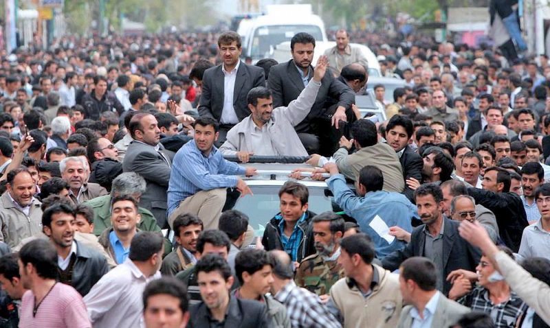 Una multitud jalea al presidente iraní, vigilado atentamente por sus guardaespaldas.