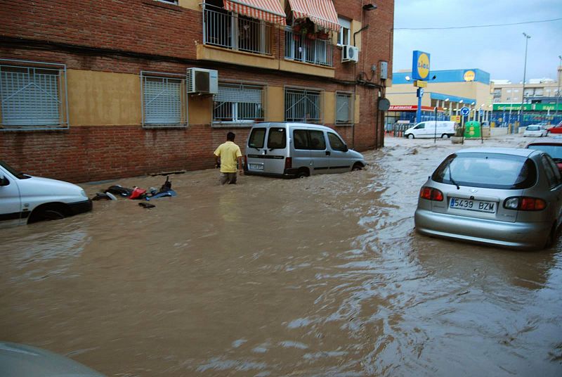 Un ciudadano de Águilas trata de cruzar una calle completamente inundada.