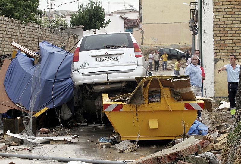 Unos vecinos observan el estado en el que ha quedado una de las calles de la localidad de Aguilar de la Frontera después de las fuertes lluvias caídas en las últimas horas en la provincia de Córdoba que han provocado más de 200 incidencias y la muert