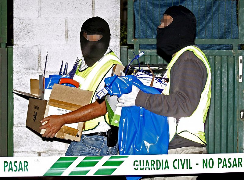Dos guardias civiles trasladan cajas con material esta noche en Ansoaín