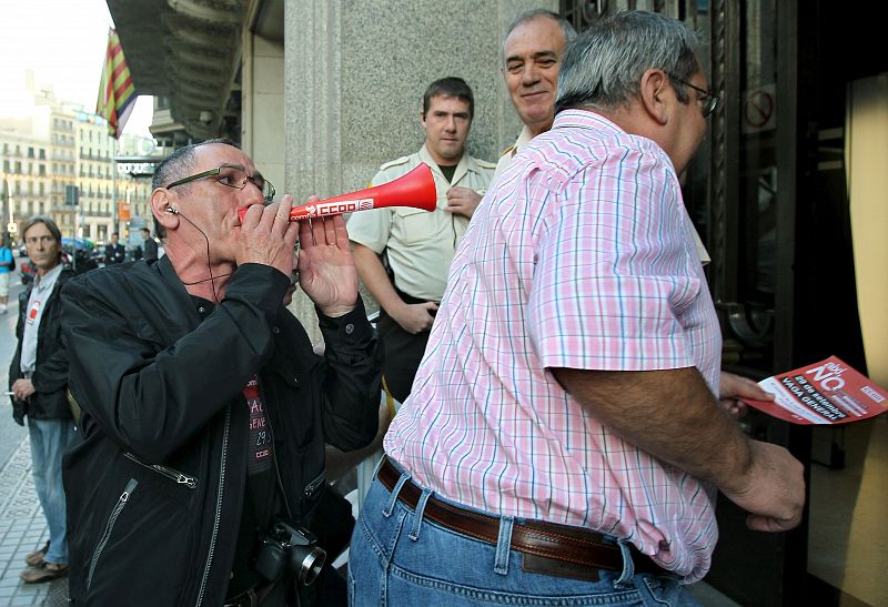 Un miembro de un piquete abuchea a los empleados de un banco del centro de Barcelona que entran a trabajar.
