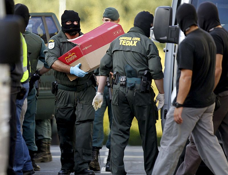 Agentes de la Guardia Civil trasladan en cajas el material incautado.