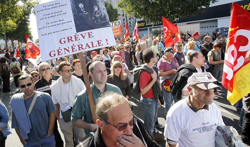 Private and public sector workers take part in a demonstration over pension reforms in Lyon