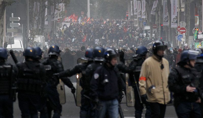 Youths face police a demonstration over pension reform in Lyon
