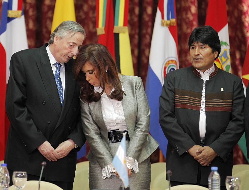 La reunión de Unasur fue una de sus últimas apariciones públicas. En la foto, conversa con su esposa y presidenta del país, Cristina Fernández en presencia de Evo Morales