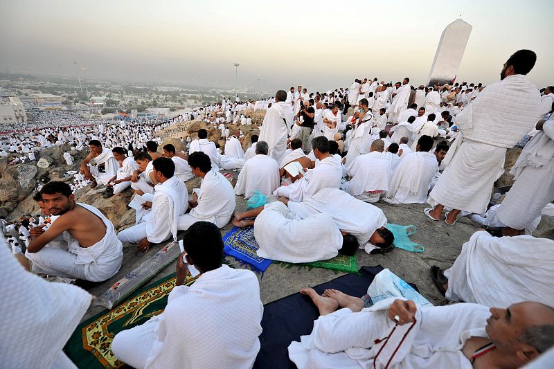 Peregrinos musulmanes realizan el rezo de alba antes de la salida del sol sobre Gebel Rahmah en el monte Arafat