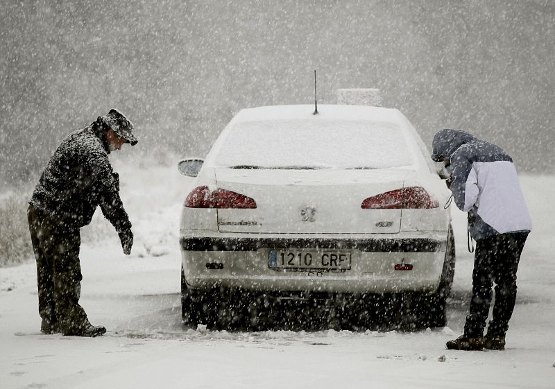 Varias personas juntoa su coche en el municipio de Roncesvalles, en Navarra.