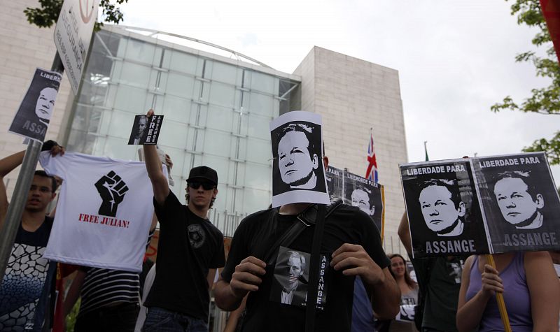 Protester holds pictures in support of WikiLeaks founder Julian Assange during a demonstration in front of the British Consulate in Sao Paulo