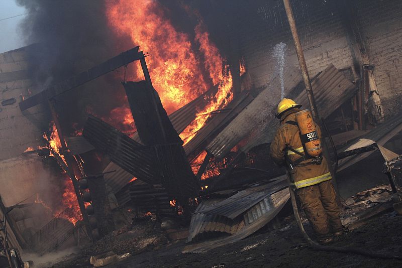 A firefighter tries to put out a fire at the area of an explosion of a Pemex pipeline in the village of San Martin Texmelucan