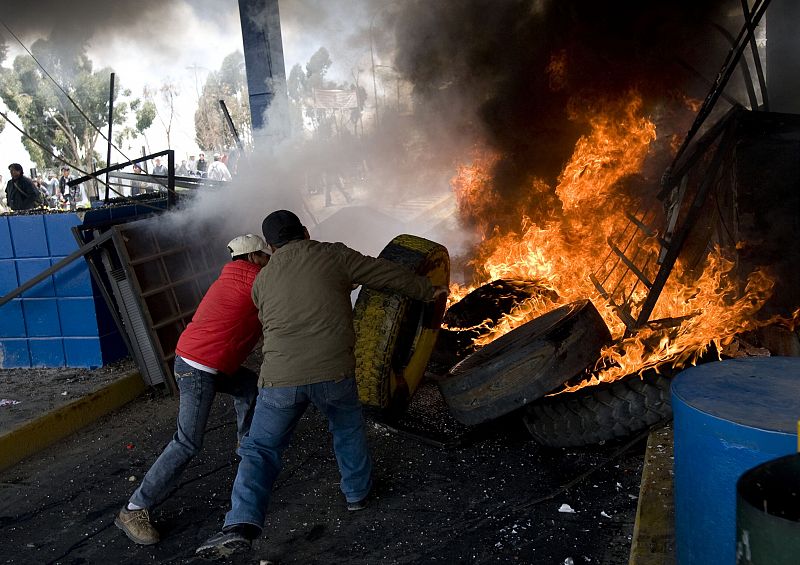 Dos de los manifestantes quemando varios neumáticos en uno de los peajes asaltados