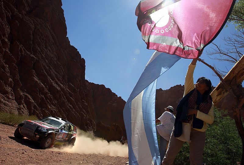 Un espectador ondea la bandera argentina mientras el BMW del ruso Leonid Novitskiy pasa en la tercera etapa del Rally Dakar 2011.