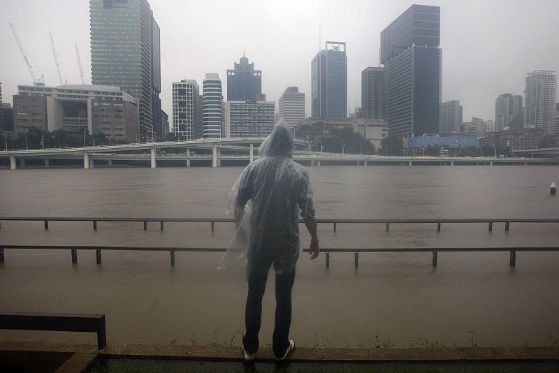 Un hombre observa cómo se ha desbordado el río Brisbane en Australia