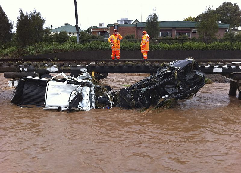 Trabajadores de los servicios de emergencias trabajan junto a las vías del tren en Toowoomba