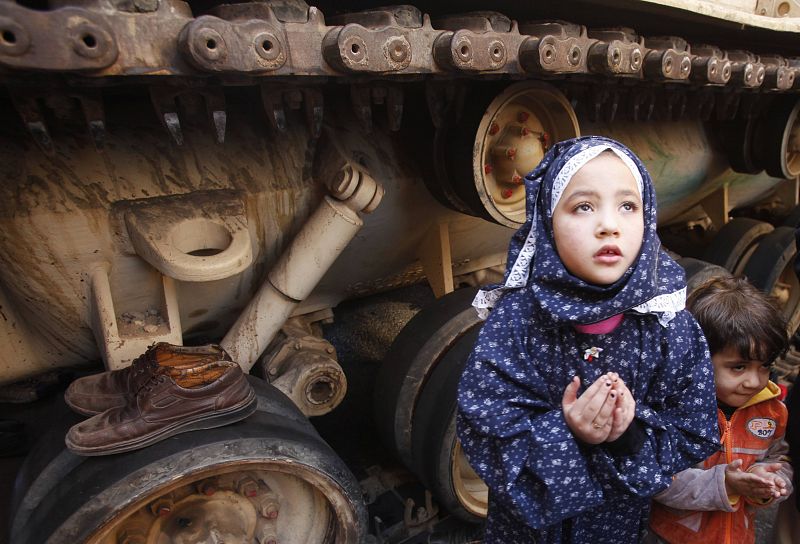 Una niña reza junto a un tanque en la plaza Tahrir durante la oración del viernes.