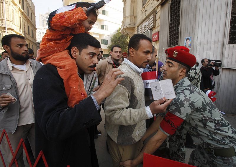 Un soldado controla la entrada a la plaza Tahrir de los egipcios que se acercan para seguir la oración del viernes.