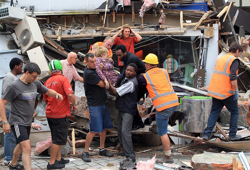Equipos de rescate y voluntarios sacan a una mujer de un edificio de la ciudad de Christchurch