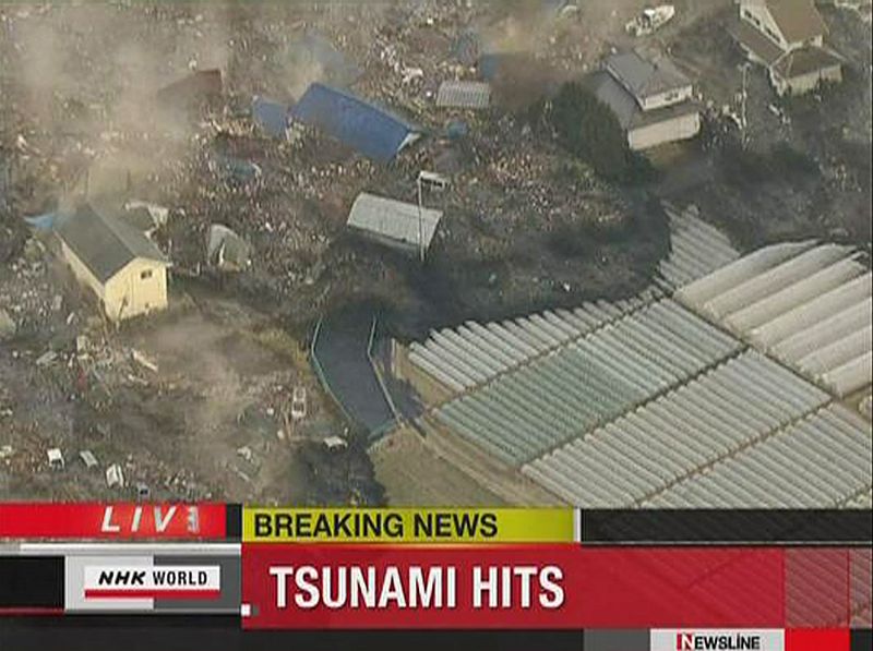 Frame grab of a tsunami carrying buildings across water in Sendai