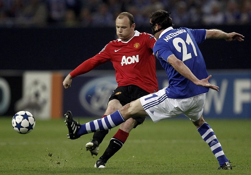 Metzelder of Schalke 04 challenges Manchester United's Rooney during their Champions League soccer match in Gelsenkirchen