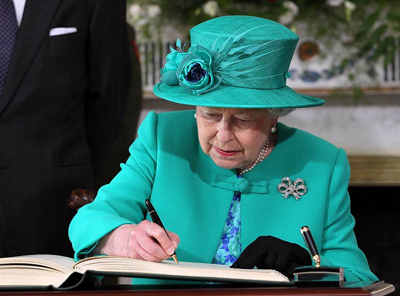 La reina Isabel II firma el libro de visitas de la residencia presidencial de Irlanda