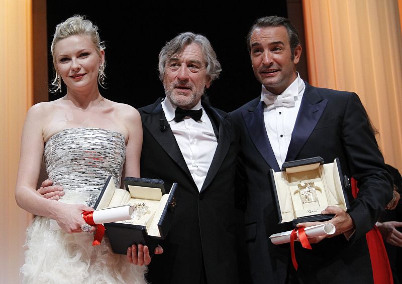 El presidente del jurado de Cannes, Robert de Niro, posa con los actores premiados, Jean Dujardin ('The Artist') y Kirsten Dunst ('Melancholia'), durante la ceremonia de clausura del festival