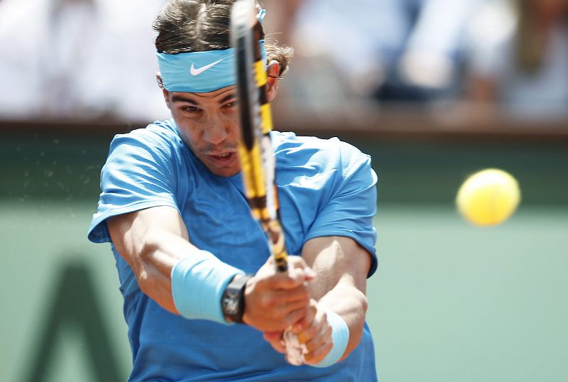 El tenista español Rafa Nadal respnde la pelota al suizo Roger Federer en la final del torneo de Roland Garros en París. El manacorí se defendía 'como gato panza arriba' en los primeros compases del encuentro.