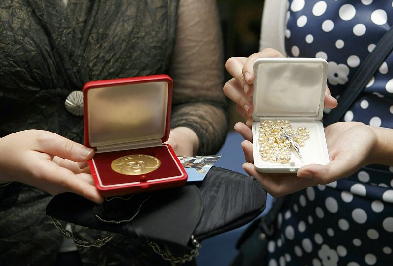 Detalle del rosario y la medalla, obsequio del papa Benedicto XVI, tras el almuerzo que han compartido un grupo de jóvenes católicos