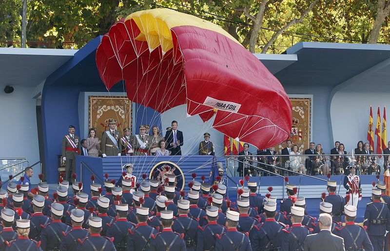 Un paracaidista ante el palco de autoridades del desfile