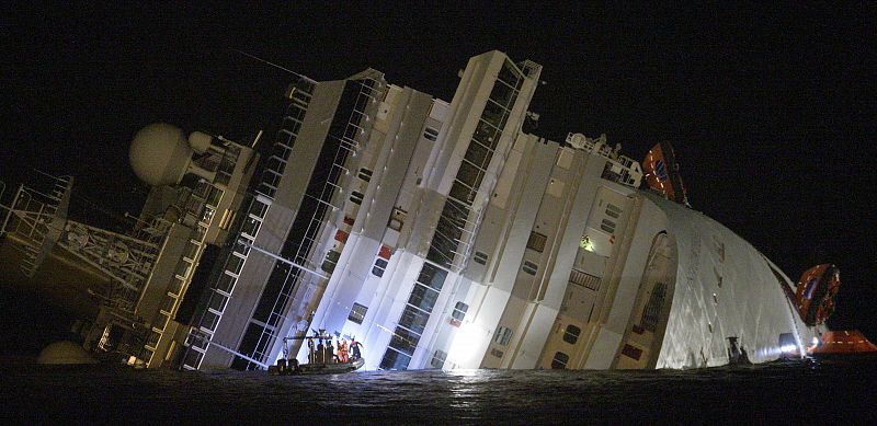 Rescuers are seen next Costa Concordia cruise ship that ran aground off the west coast of Italy at Giglio island
